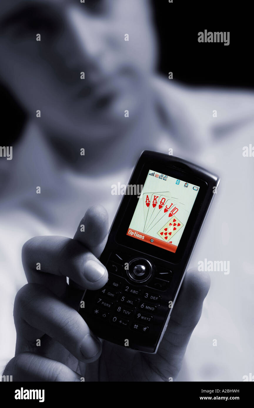 Jeune homme montrant royal flush sur téléphone mobile Banque D'Images