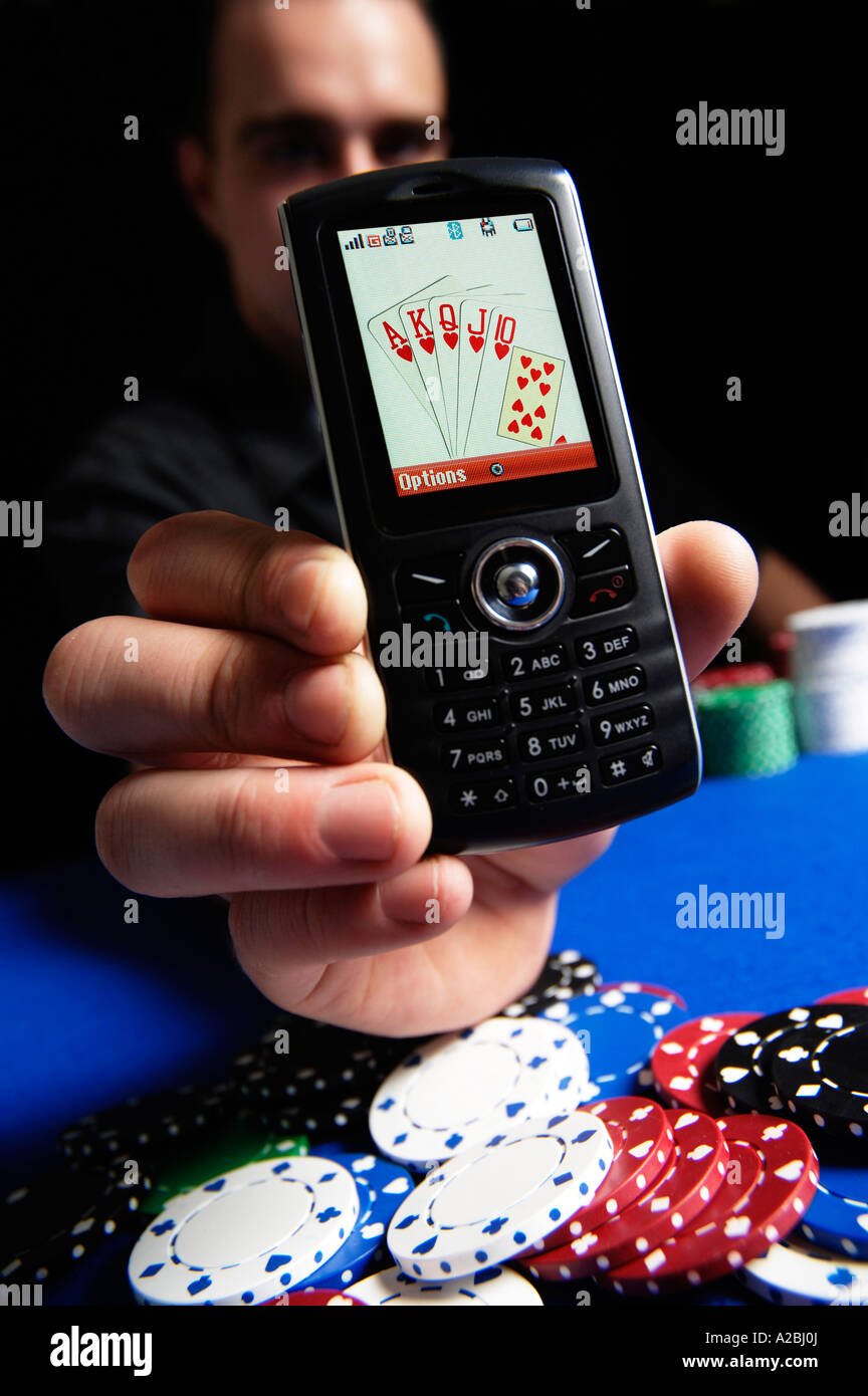 Jeune homme montrant Royal Flush sur téléphone mobile Banque D'Images