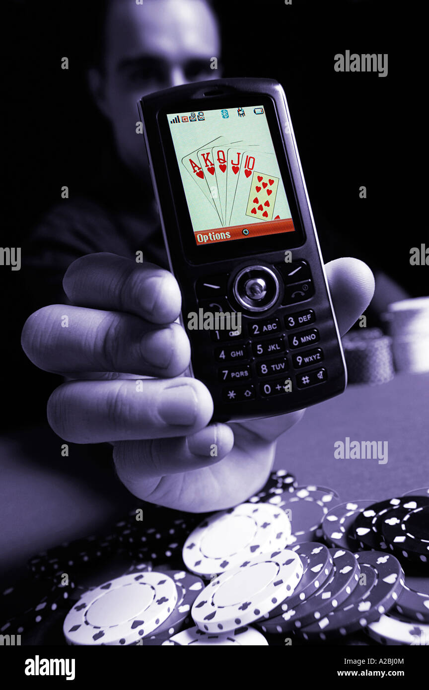 Jeune homme montrant Royal Flush sur téléphone mobile Banque D'Images