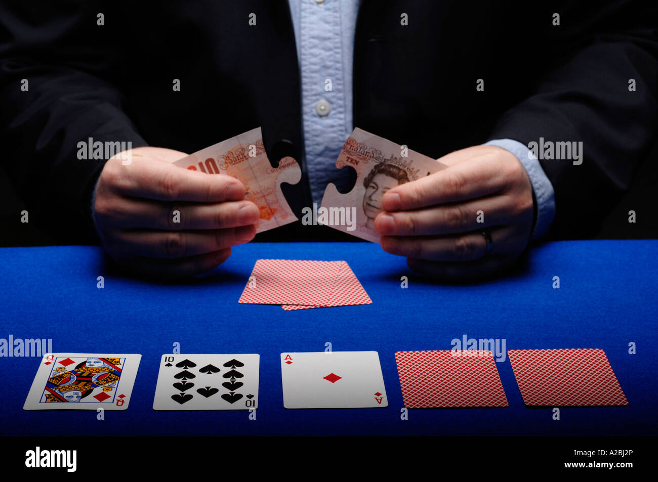 Man holding dix livre puzzle at poker table Banque D'Images