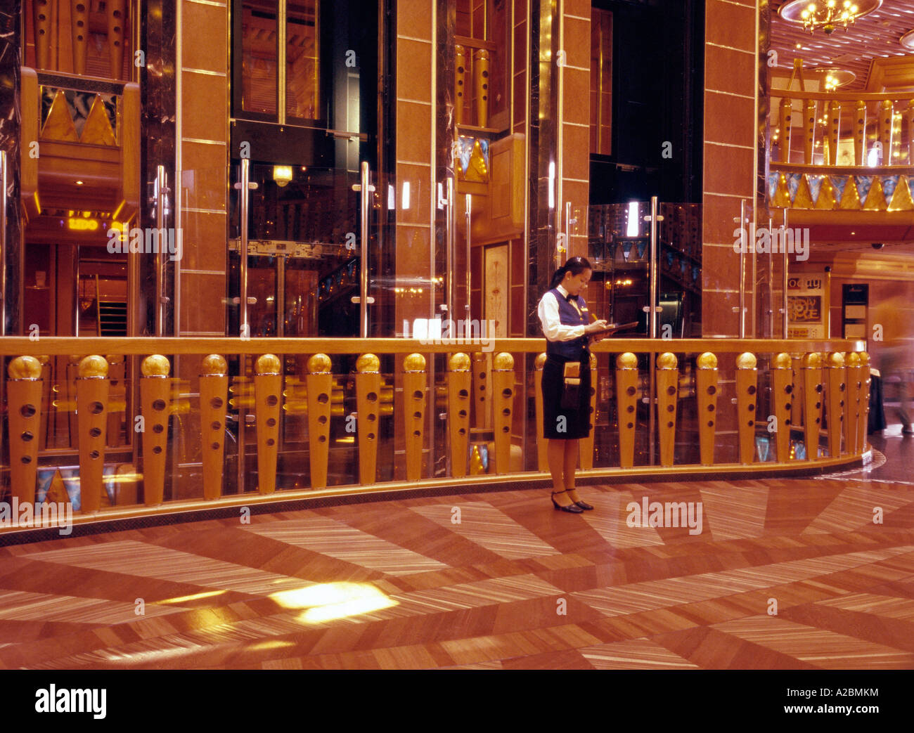 Une serveuse asiatique notes écrit debout sur le hall central du navire de croisière Costa Magica Banque D'Images