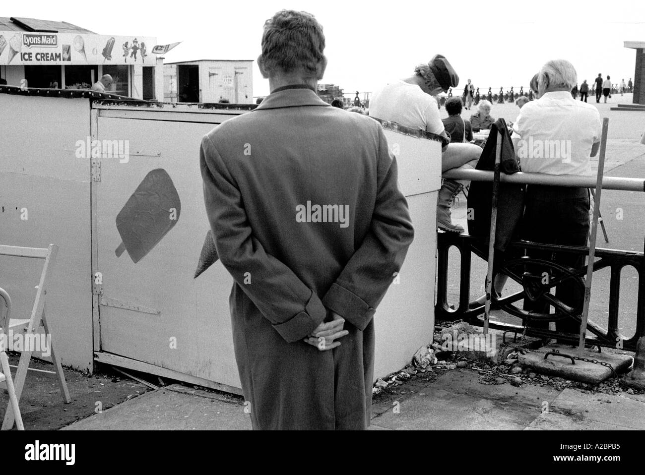 Retour de l'homme à l'imperméable brighton Angleterre 1979 ressemble à ian dury 35mm b/w Banque D'Images