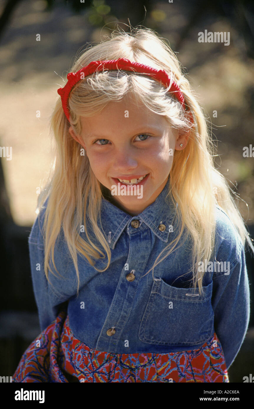 Portrait de 8 à 10 ans, jeune fille timide soleil souriant doux sourire à la caméra jusqu'à l'habiller de vêtements casual denim occasionnels bandeau en dehors de MR © M Banque D'Images