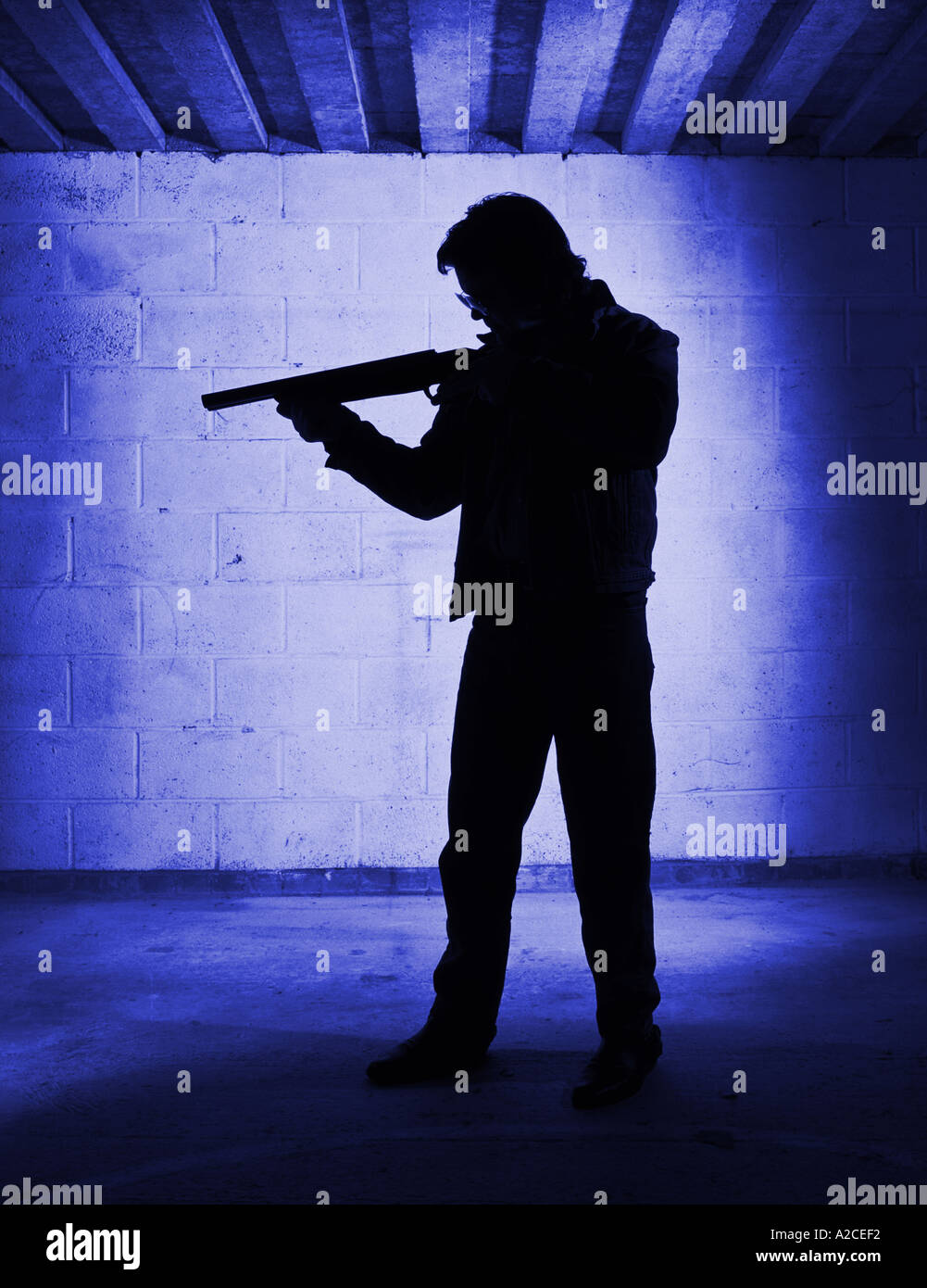 Silhouette d'ombre ou d'un homme pointant et en visant un fusil de chasse. Banque D'Images