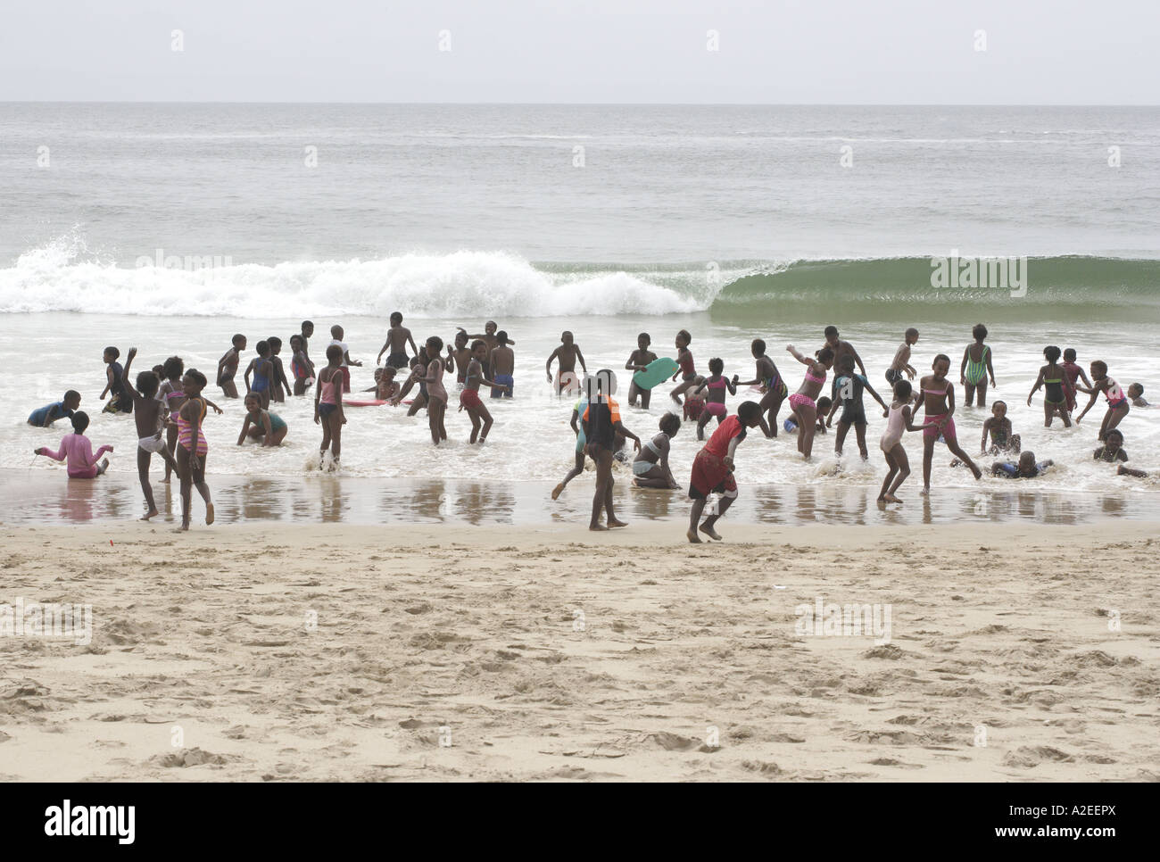 Les enfants de l'École d'Afrique du Sud à jouer dans les vagues Banque D'Images