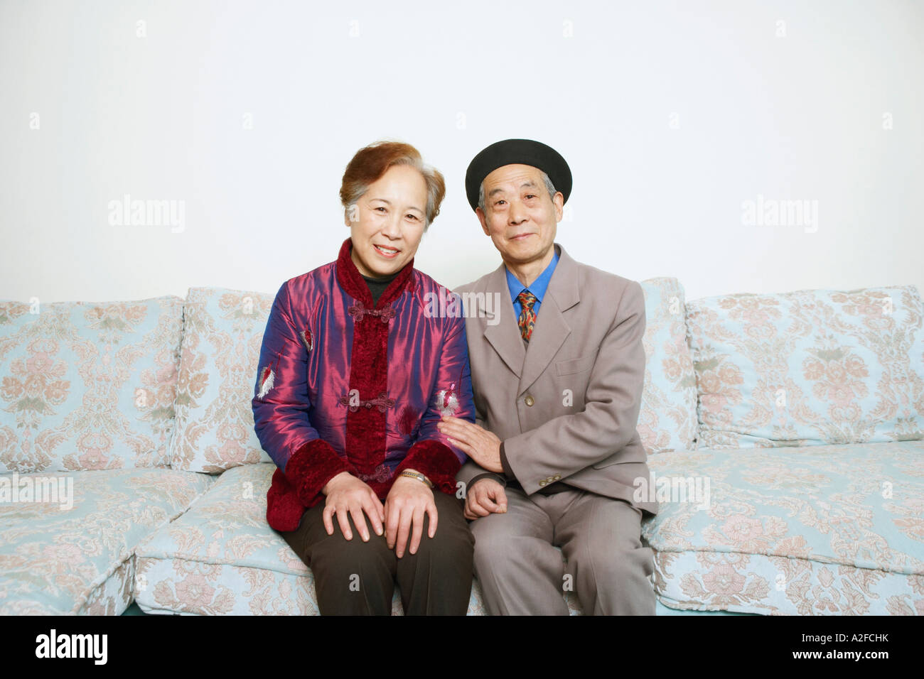Portrait of a senior man sitting on a couch with a young woman Banque D'Images