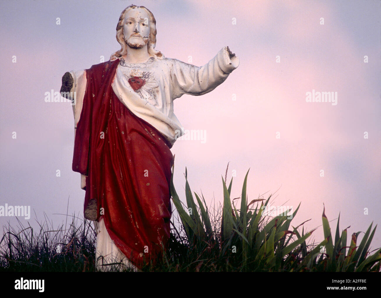 Une statue de Jésus Christ se tient devant un beau coucher de soleil à Newmarket, New Hampshire en levant les bras au ciel la statue est Banque D'Images