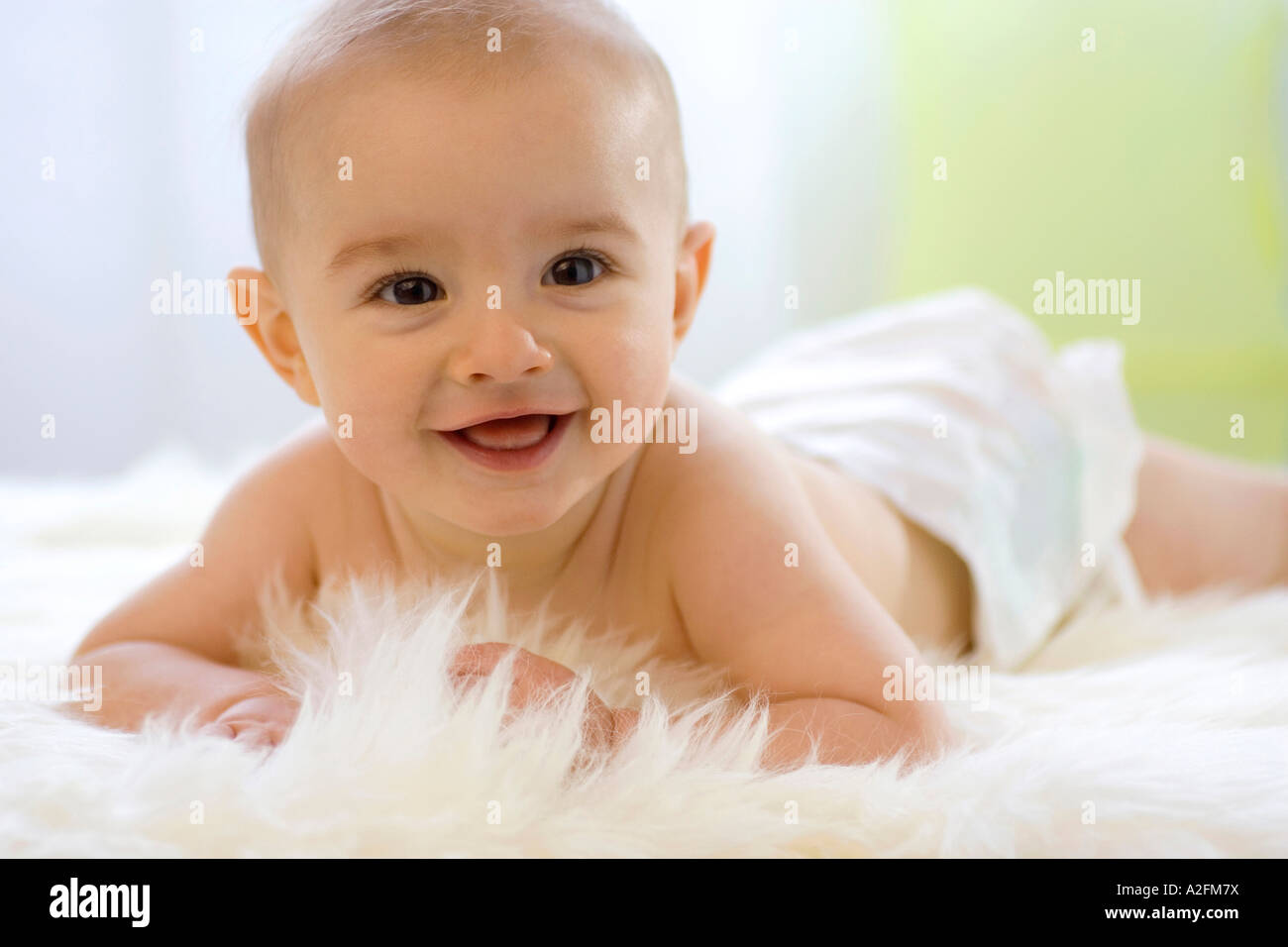 Bébé garçon (6-12 mois) allongé sur le ventre, smiling Banque D'Images
