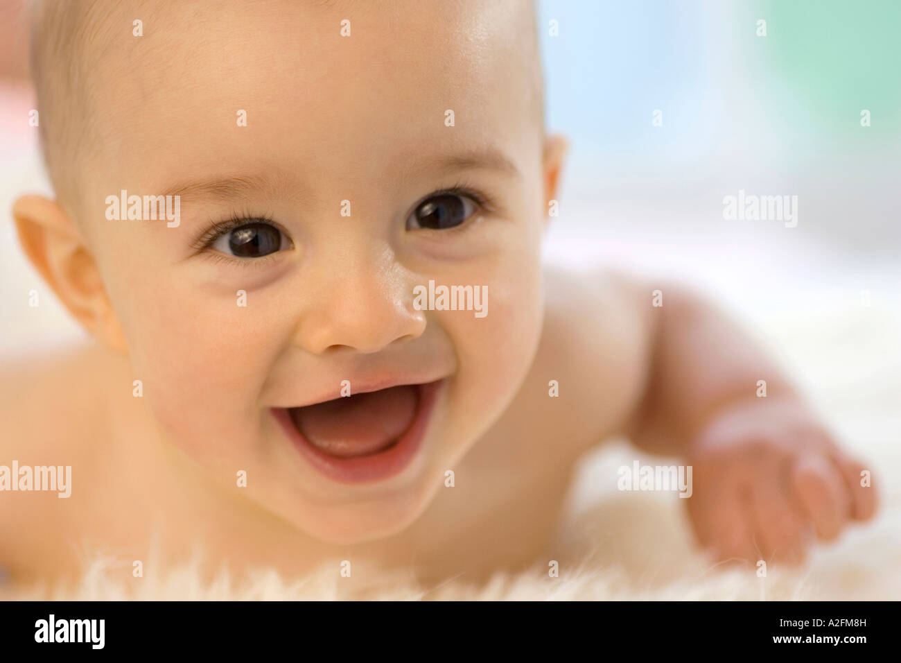 Bébé garçon (6-12 mois) allongé sur le ventre, smiling, close-up Banque D'Images