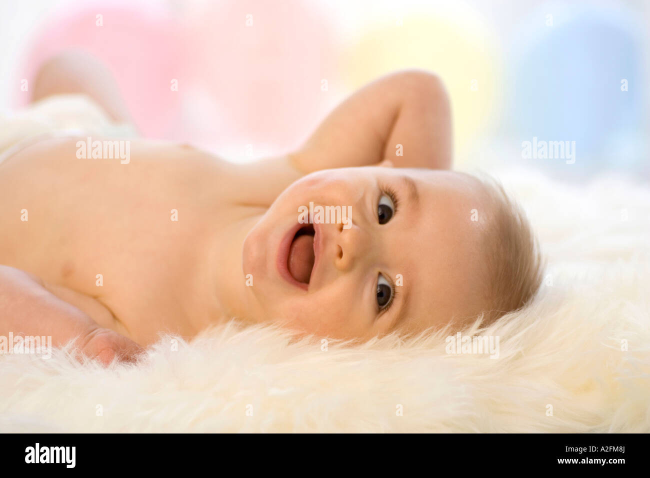 Bébé garçon (6-12 mois) allongé sur le dos, riant Banque D'Images