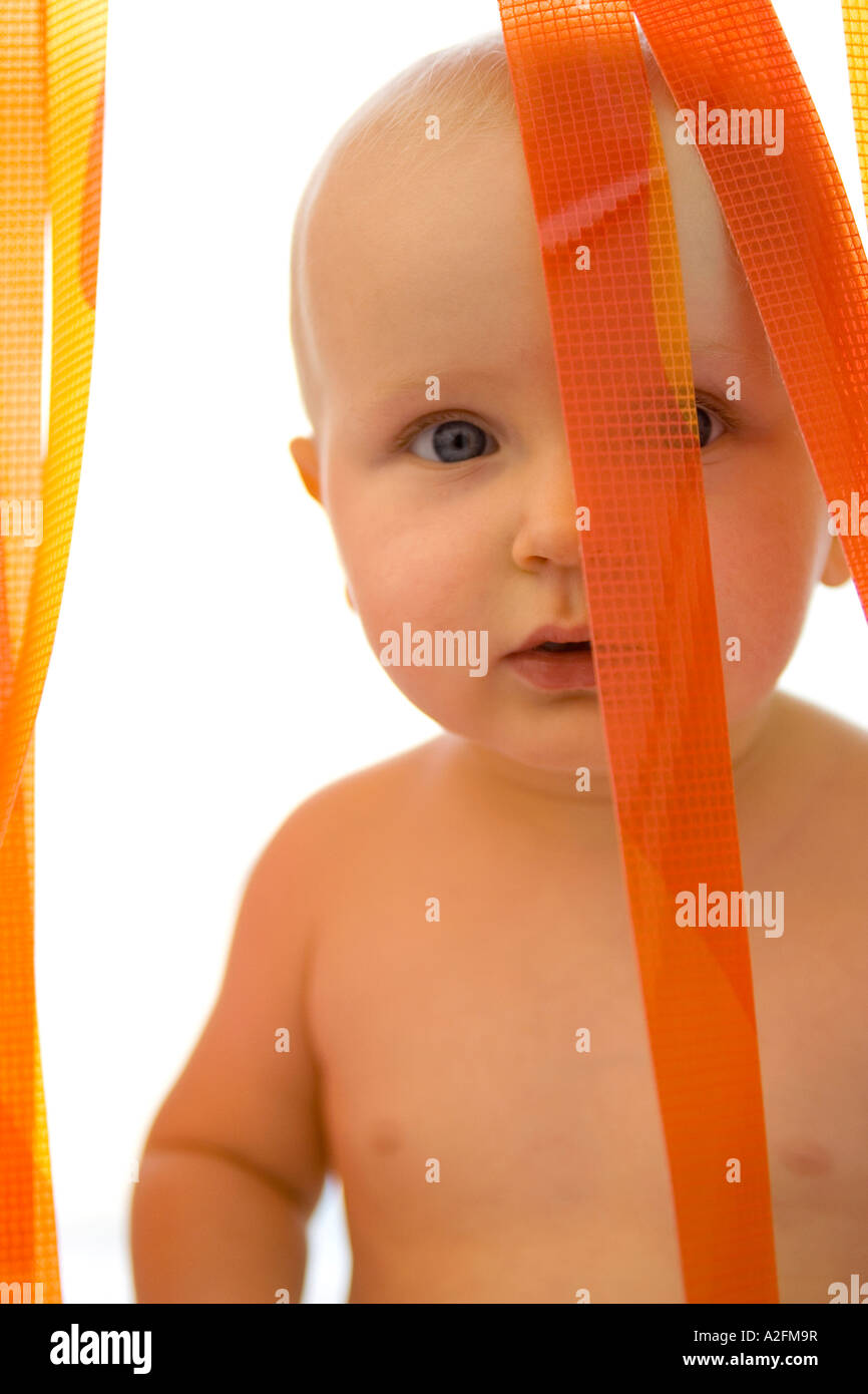 Bébé garçon (6-12 mois) par rideau en plastique Banque D'Images