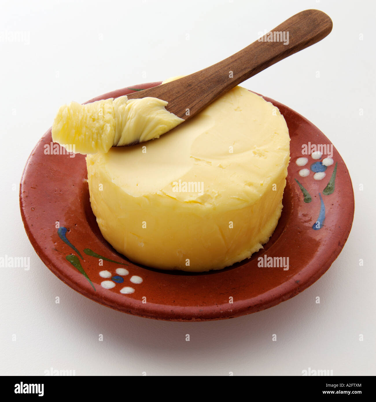 Une noix de beurre avec un couteau sur le dessus sur fond blanc Banque D'Images