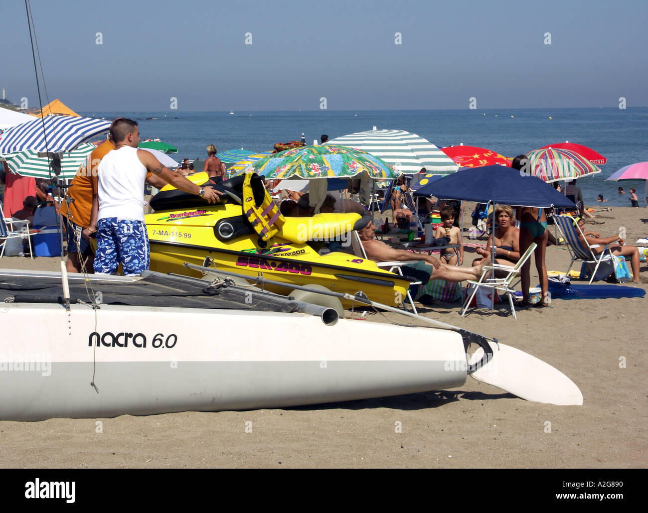 Les hommes poussant Jet Ski sur un chariot en face de la plage, à La Cala de Mijas, Mijas Costa, Costa del Sol, Espagne, Europe, Banque D'Images