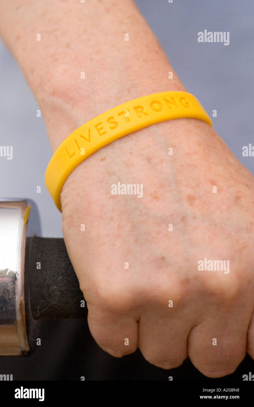 Woman wearing yellow Lance Armstrong Livestrong bracelet plastique holding  haltères Photo Stock - Alamy