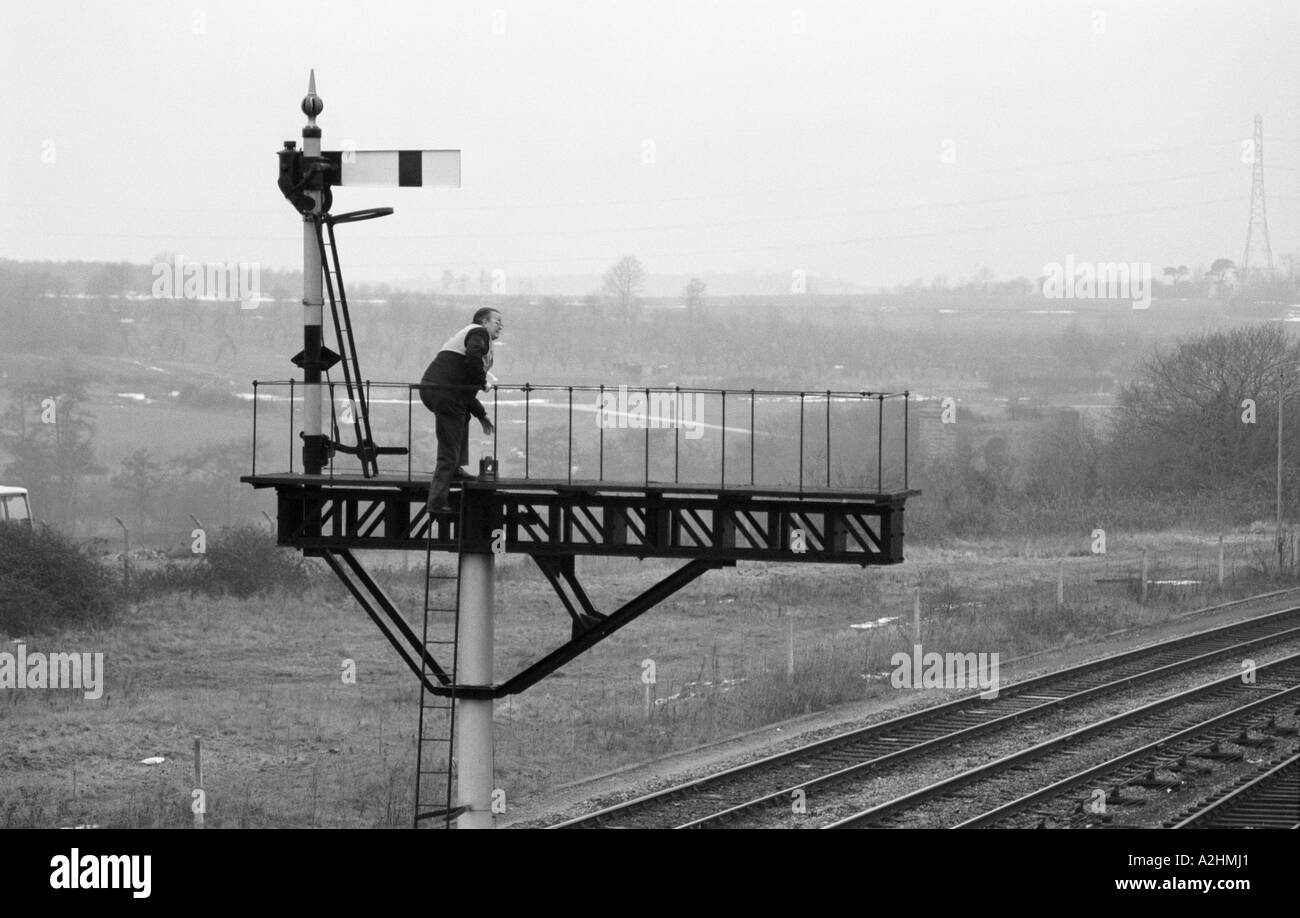 L'homme de fer sur de remplacement de lampe signal sémaphore, Evesham, Worcestershire, Angleterre, Royaume-Uni Janvier 1987 Banque D'Images