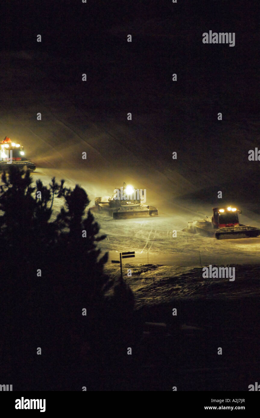 Piste bashers avec feu de croisement la préparation de piste de ski de nuit dans les alpes françaises Banque D'Images