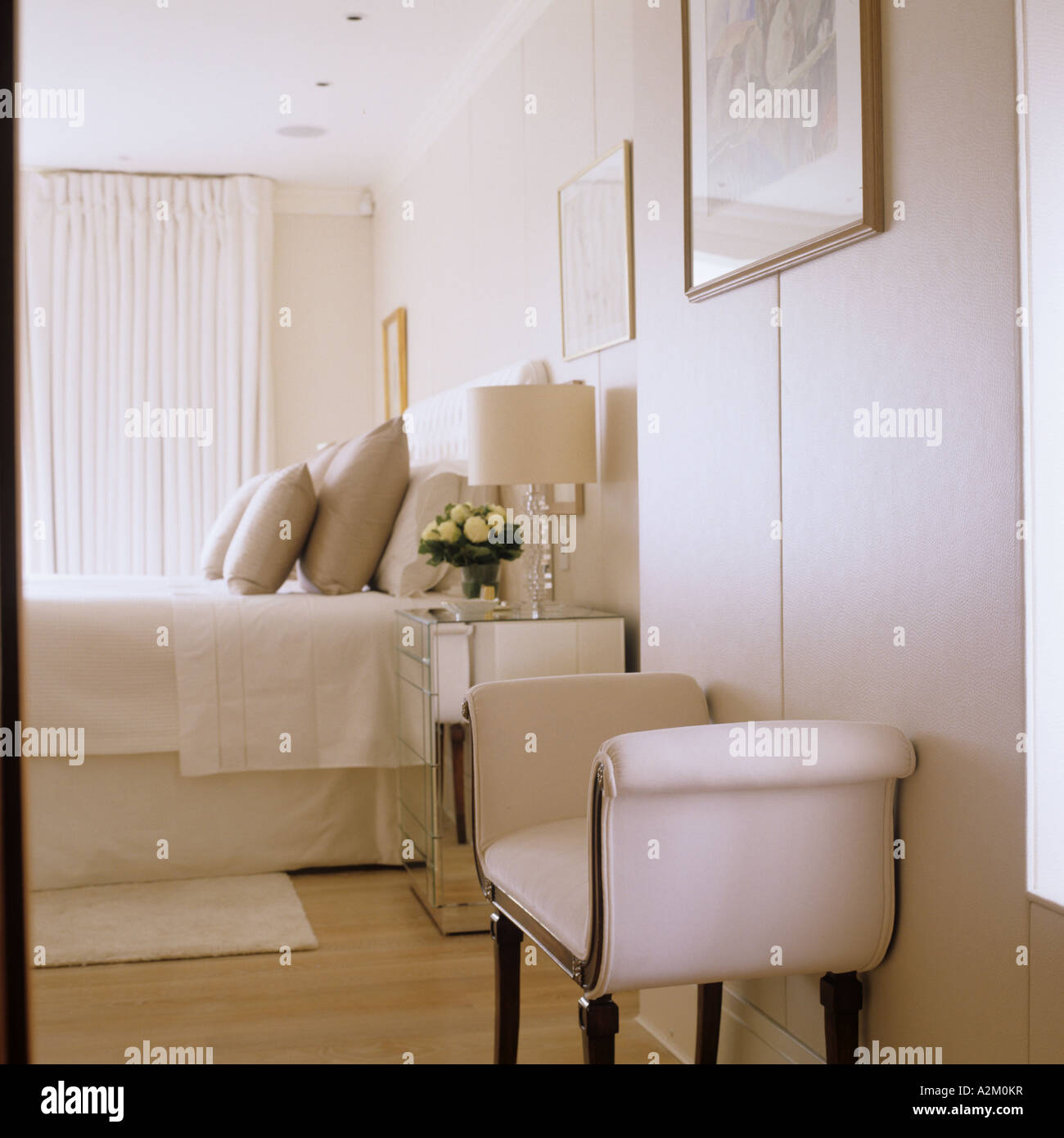 Chambre avec lit double et canapé crème matelassé en télévision avec un design intérieur par Emily Todhunter Banque D'Images