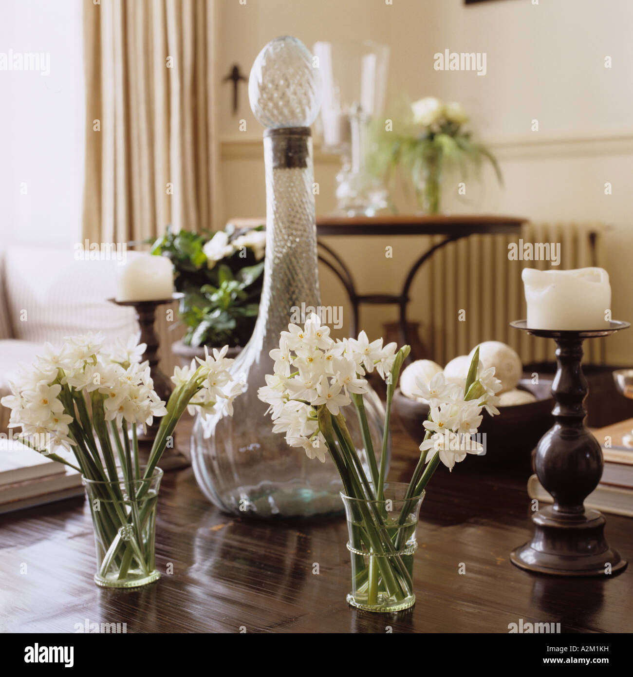 Carafe en verre blanc et les jonquilles sur table en bois Banque D'Images