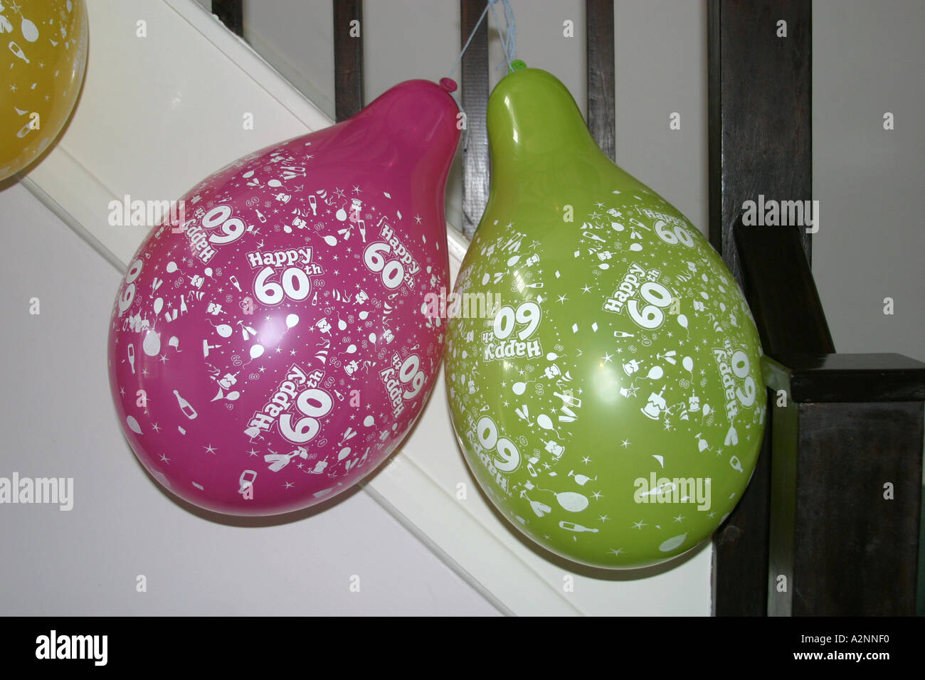 Deux ballons de couleur vive 60e anniversaire de la pendaison aux rampes dans hall Banque D'Images