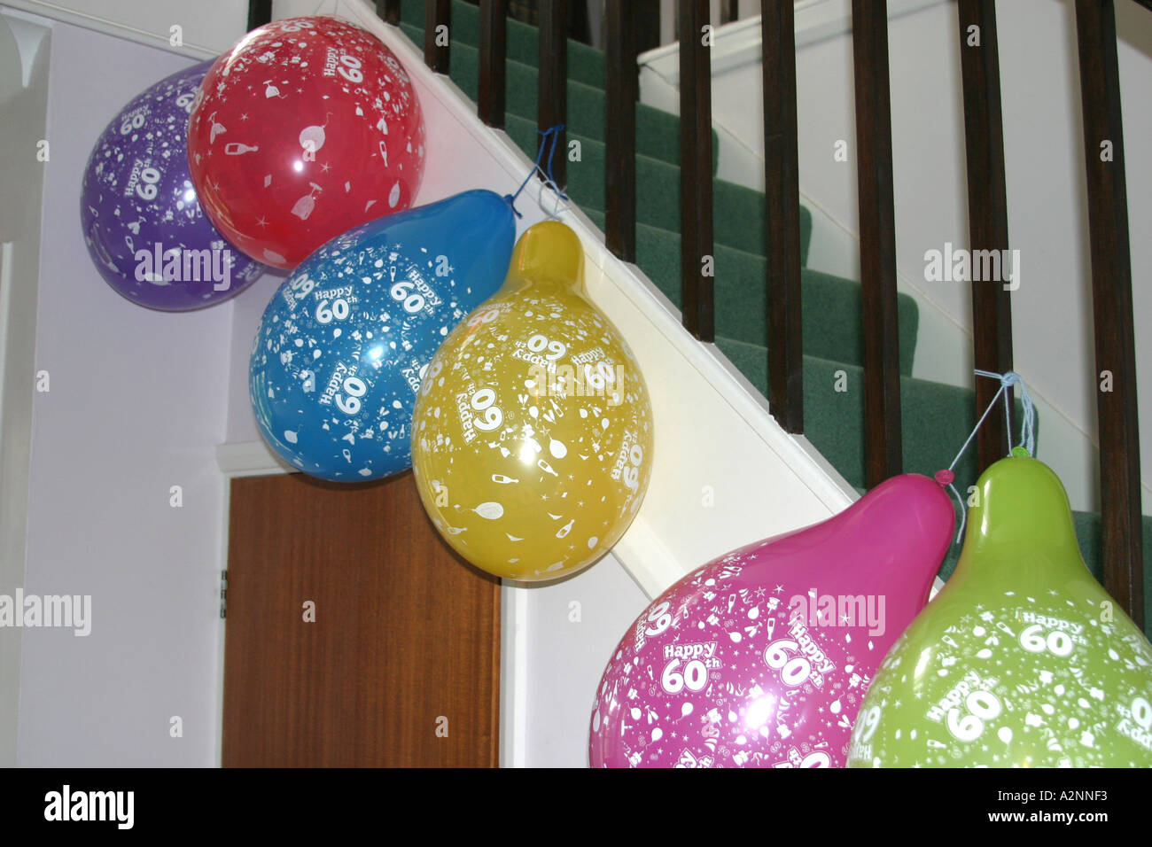 60e anniversaire ballons colorés suspendus aux rampes dans hall Banque D'Images