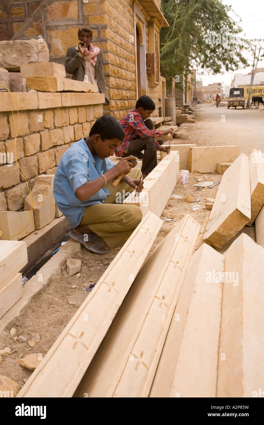 Inde Rajasthan Jaisalmer jeune apprenti maçon décoration sculpture sur le linteau en pierre Banque D'Images