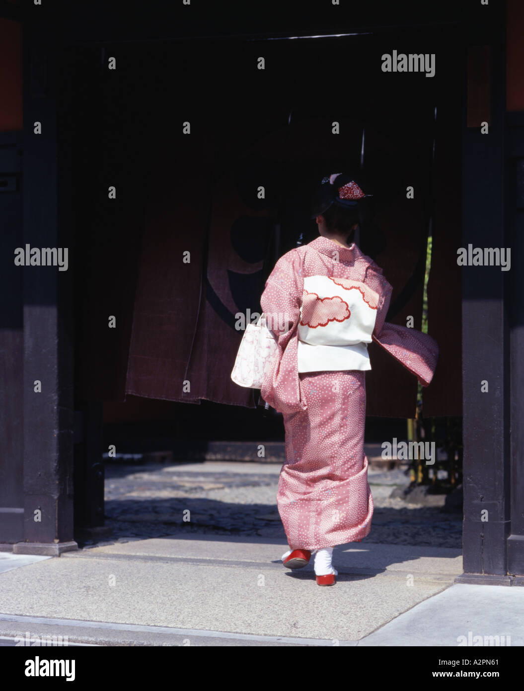 Kimono japonais portant des promenades à travers les rues de Gion de Kyoto et de la porte entre dans le restaurant exclusif Banque D'Images