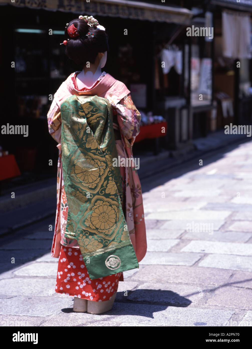 Fille de stagiaire costume Geisha maiko marche le long de la rue de Kyoto Gion portant perruque obi kimono parasol makeup Banque D'Images