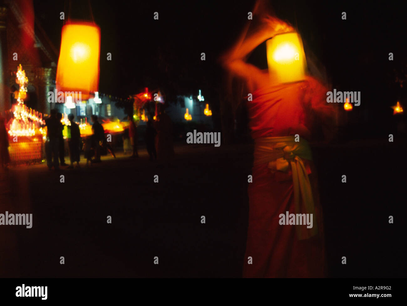 Un moine décore un wat avec des lanternes pour l'Awk Phansa célébration pour marquer la fin de la saison de la mousson, Luang Prabang au Laos Banque D'Images