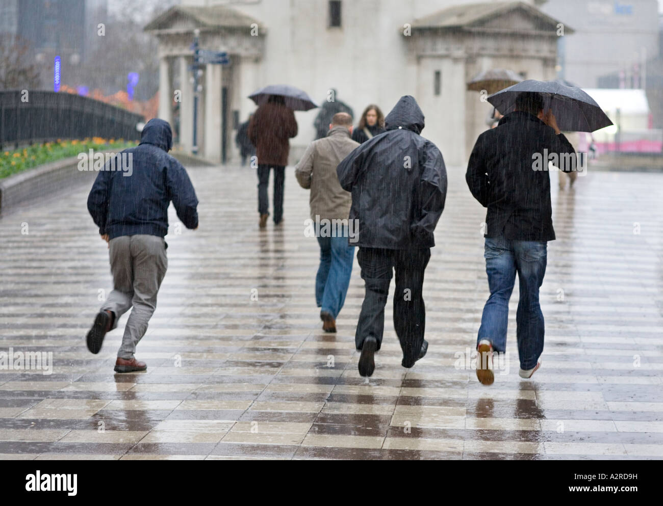 Les piétons qui traversent façon centenaire à Birmingham, Royaume-Uni, pendant une tempête de pluie Banque D'Images