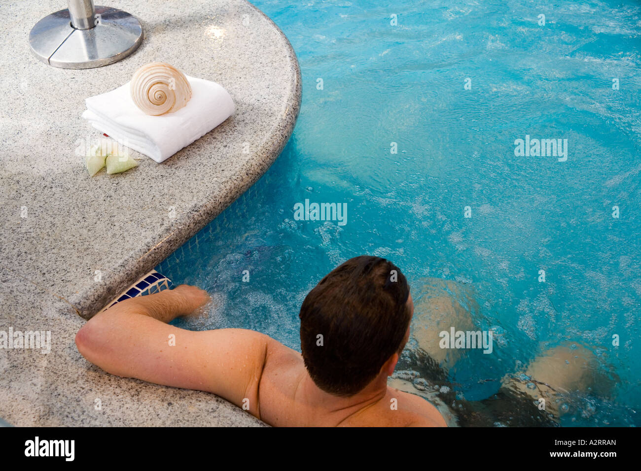 Jeune homme enjoing vacances en piscine se reposant dans un SPA Banque D'Images