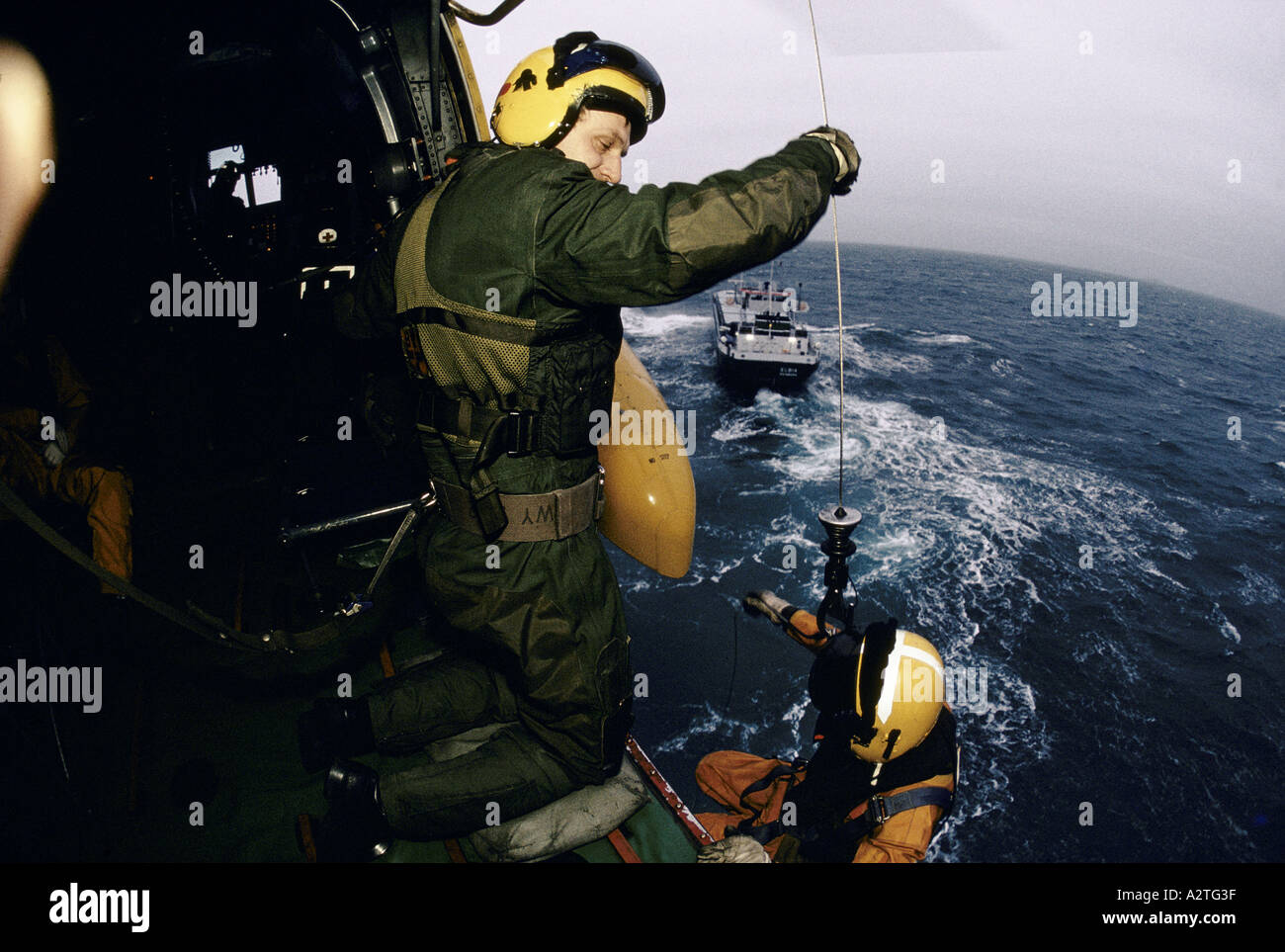 Sauvetage en mer de l'air hélicoptère Sea King winchman exercice étant abaissée sur la hausse et la baisse navire 30 ft dans la houle 1987 Banque D'Images