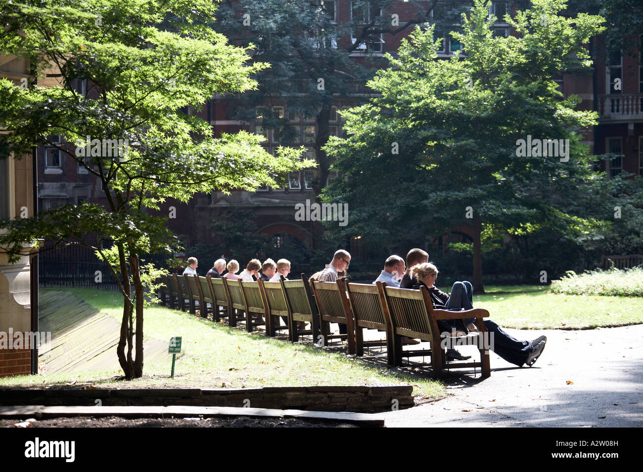 Des gens assis sur des bancs à l'heure du déjeuner dans les jardins de Mount Street, à la fin de l'été à Mayfair Londres W1 Angleterre Banque D'Images