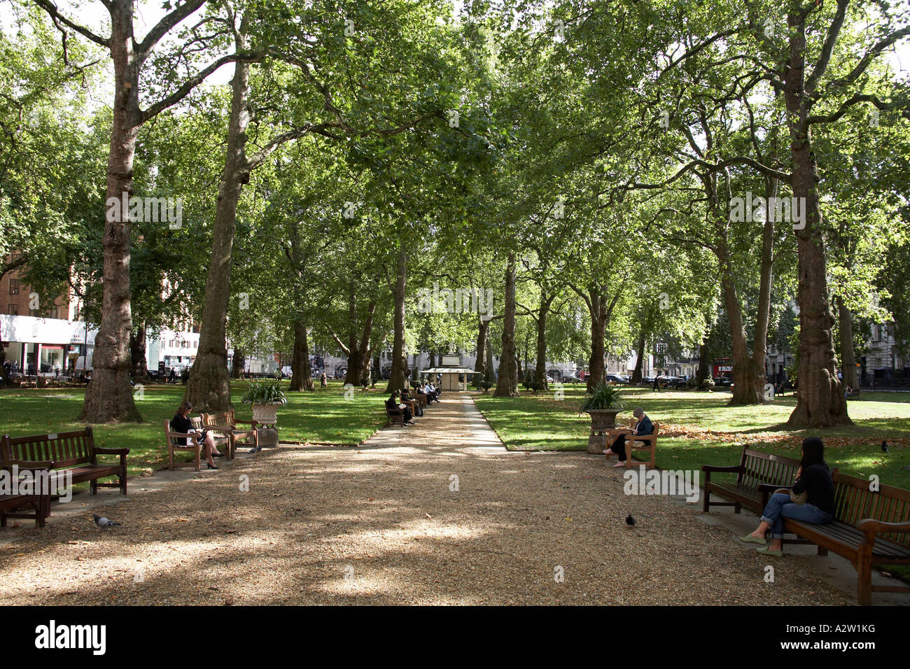 Des gens assis et de détente en plein air dans la région de Berkeley Square sur une fin de l'été pause déjeuner à Mayfair Londres W1 Angleterre Banque D'Images