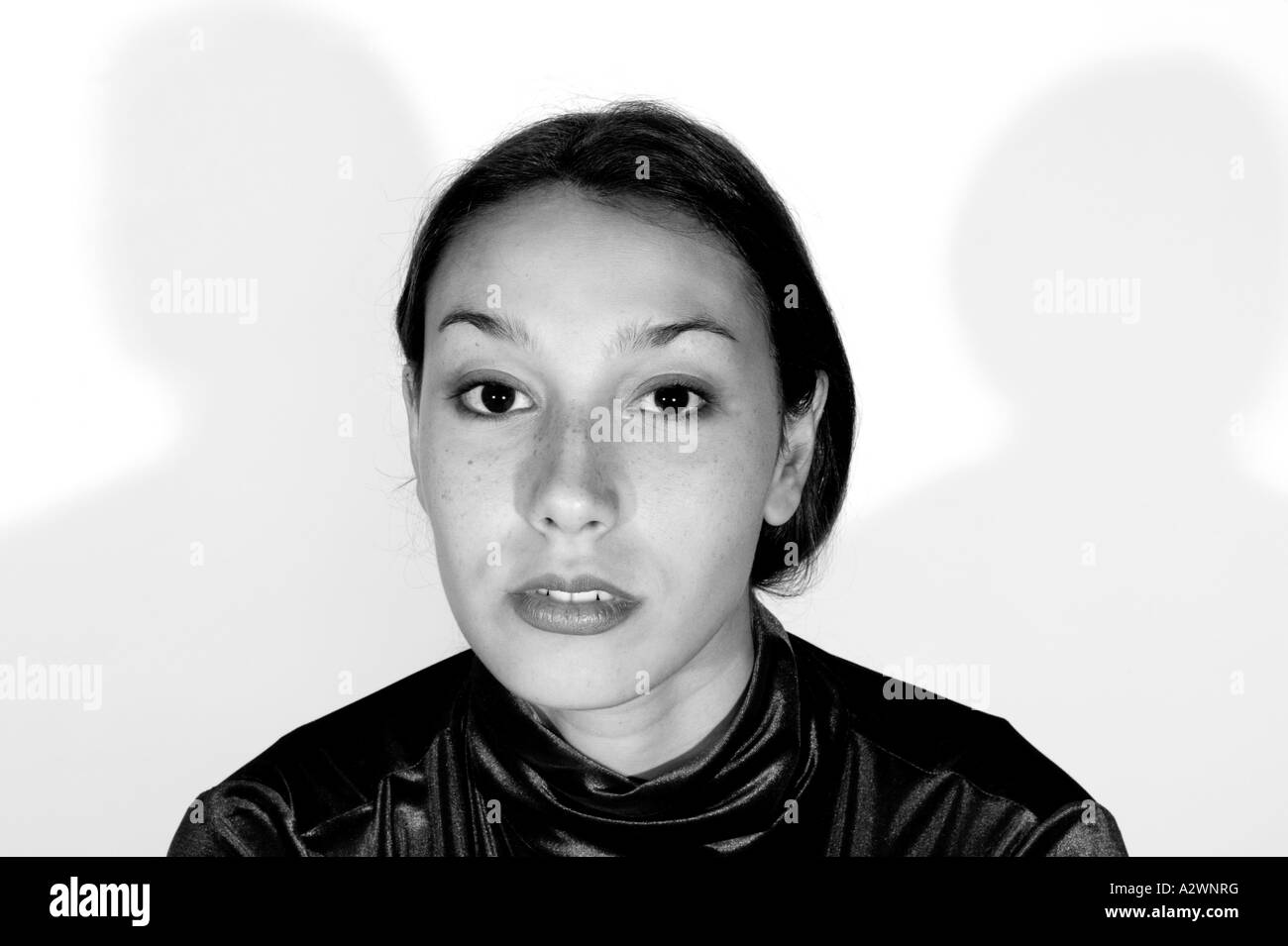 Young woman standing by wall, portrait Banque D'Images