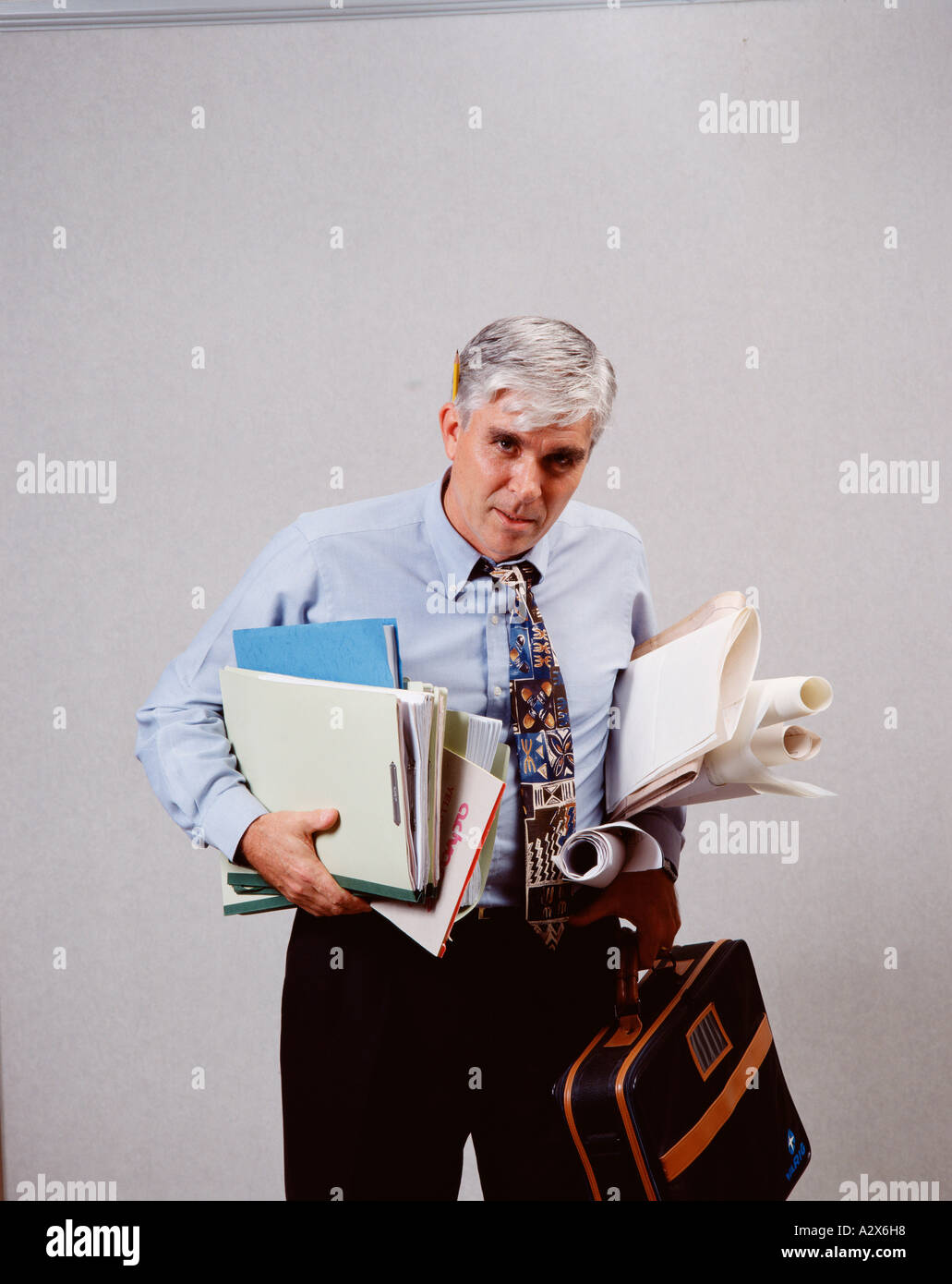 Middle aged man holding formalités administratives et à la recherche a souligné et surchargé. Banque D'Images