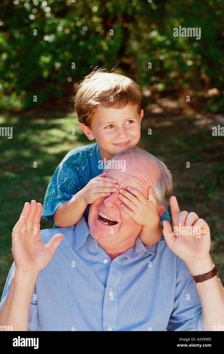 Grand-père et petit-fils. Vieil homme et jeune garçon de 6 ans. Close-up à l'extérieur dans le jardin. Banque D'Images