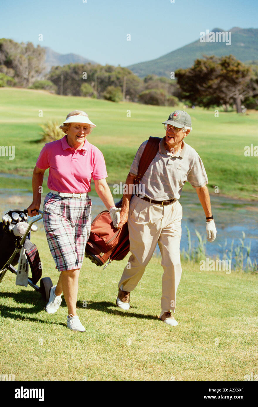 L'âge de la retraite l'homme et la femme à marcher ensemble sur le parcours de golf. Banque D'Images