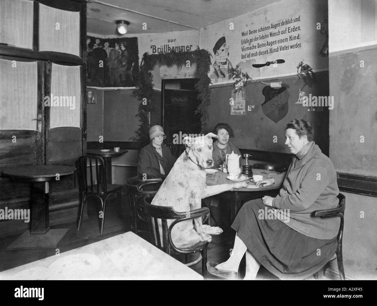 Un café complet avec Strapping Dog dans la taverne étudiante historique de Berlin de ce nom, il est douteux si les rassemblements dans cet établissement vieux de 100 ans ont toujours été si mortels que c'était le repaire des fraternités étudiantes en duel la porte de la salle où leurs réunions ont eu lieu la salle des cris peut être vu dans le fond Dieses Kaffeekraenzchen tagt samt strammen Hund in Berlin an historischer Staette es ist zu bezweifeln dass es im 100 Jahren alten Studentenlokal Zum Strammen Hund immer SO gesittet zugeht wenn sich die schlagenden Corpsstudenten einfinden Im Hintergrund der Banque D'Images