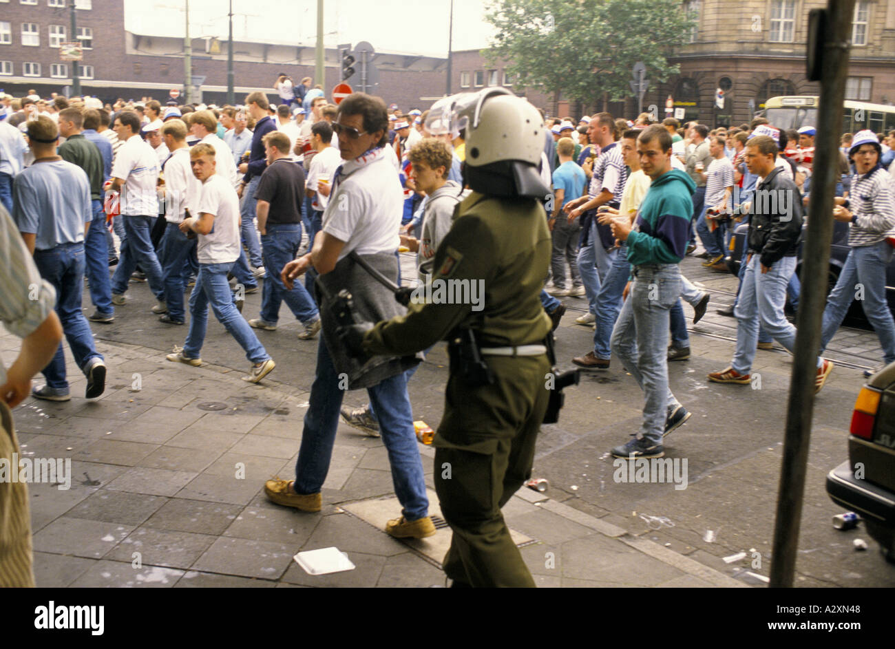 L'Allemagne de l'ouest de la police anti-émeute se déplacer le long des fans de football après des difficultés dans les rues au cours de l'Euro Cup 1988 Banque D'Images