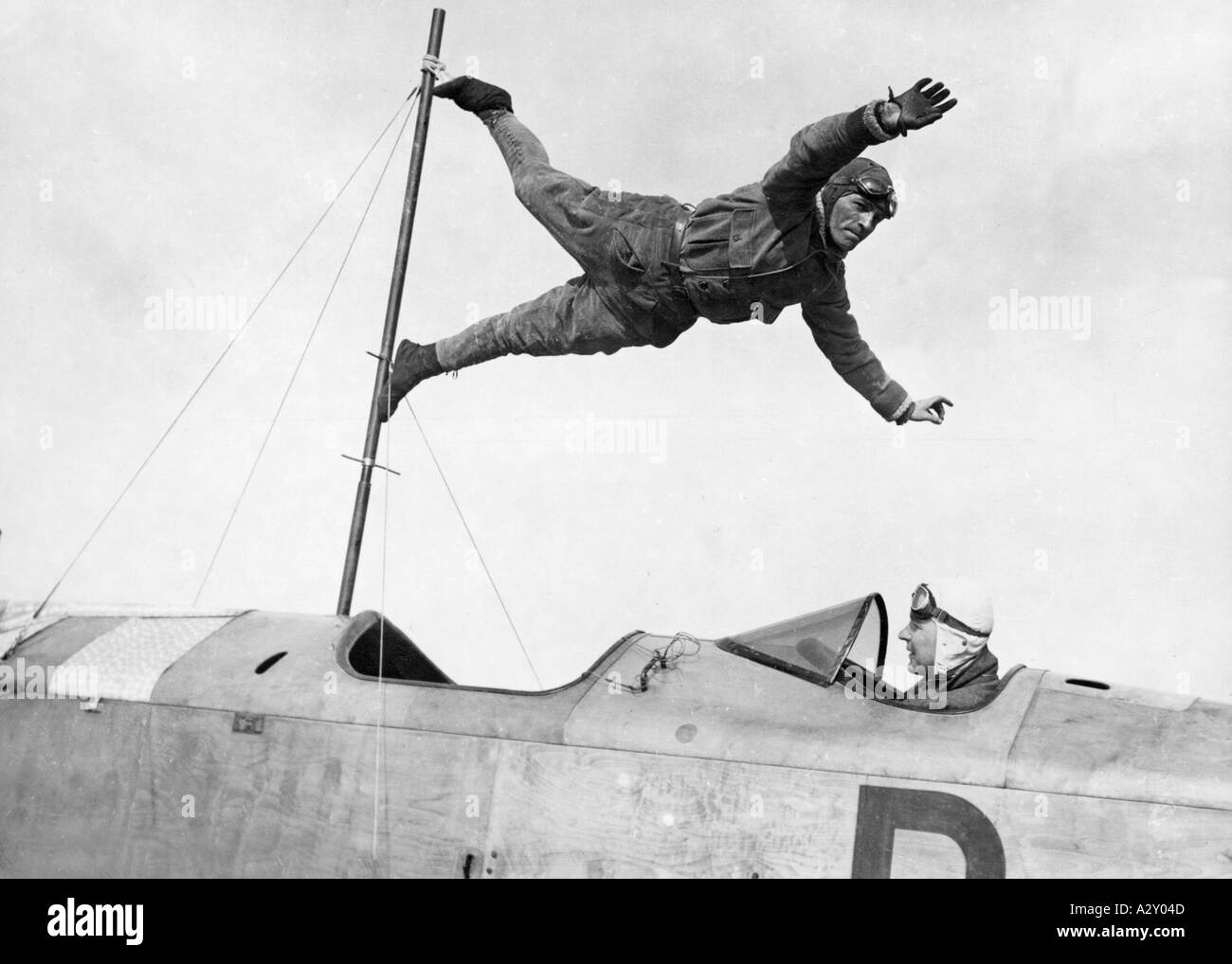 Alors que la technologie progressait à pas de géant, le premier moteur à réaction a été breveté en 1930 Open Days à Berlin L'aérodrome de Tempelhof dans les années 1930 comprenait des démonstrations d'acrobaties dans l'air gymnaste volante Fritz Schindler comme vivant girouette Waehrend sich die Technik in Riesenschritten weiterentwickelt 1930 erhaelt das erste Duesentriebwerk ein Patent wird in den dreissiger Jahren BEI einem Flugtag auf dem Berliner Flugplatz Tempelhof Akrobatik in der Luft gezeigt Flugturnkuenstler Fritz Schindler als lebende Wetterfahne moments curieux S 236 Banque D'Images