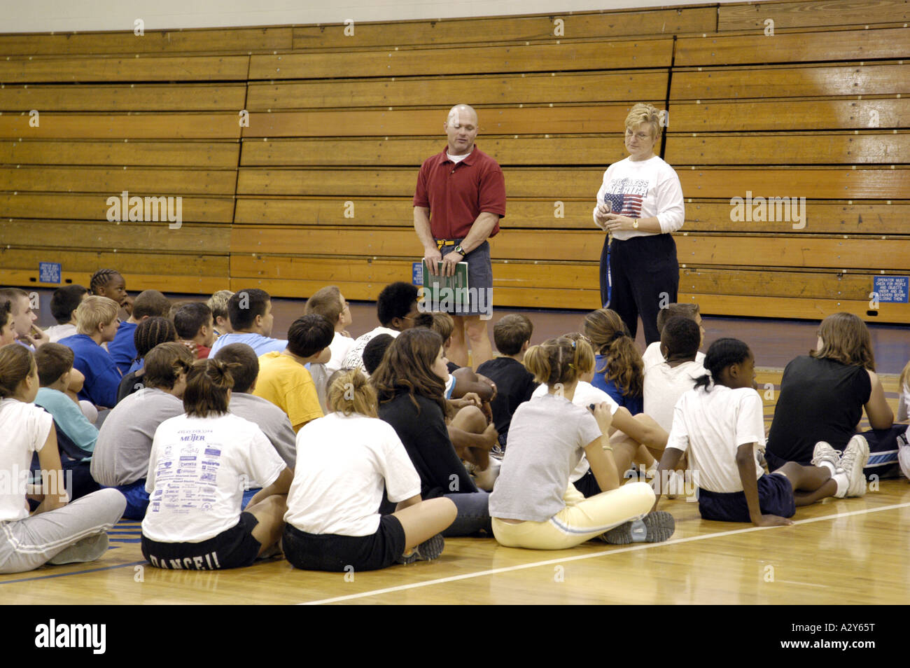 Entraîneur masculin et féminin parle avec l'équipe de basket-ball au cours d'une pratique dans un gymnase Banque D'Images