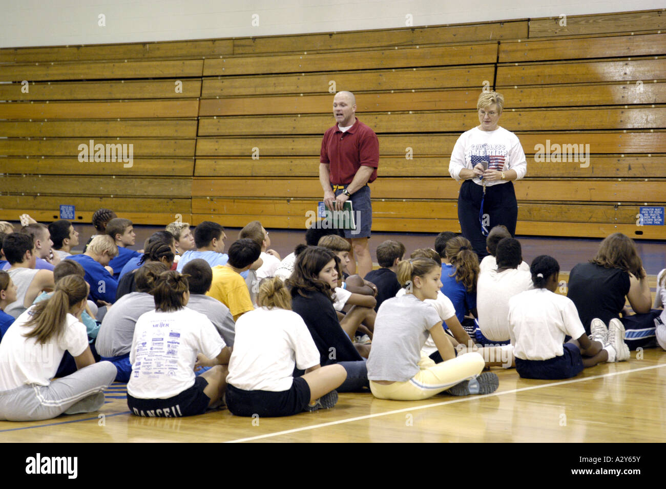 Entraîneur masculin et féminin parle avec l'équipe de basket-ball au cours d'une pratique dans un gymnase Banque D'Images