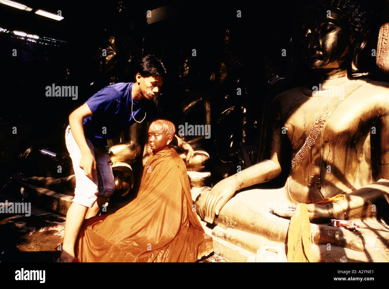 Un nettoyage de l'homme statue de Bouddha à la vente. Laque rouge est utilisé pour faire des Bouddhas chinois et de laiton pour Thai Bouddhas, Bangkok, Thaïlande Banque D'Images