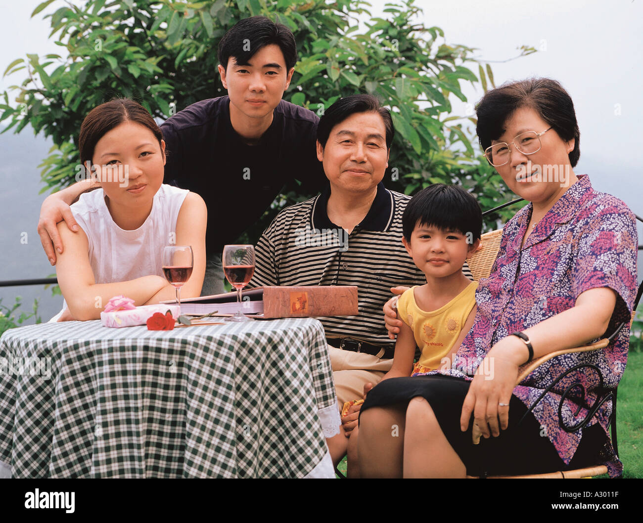 Famille chinoise assis dans une cour et en regardant les photos anciennes Banque D'Images