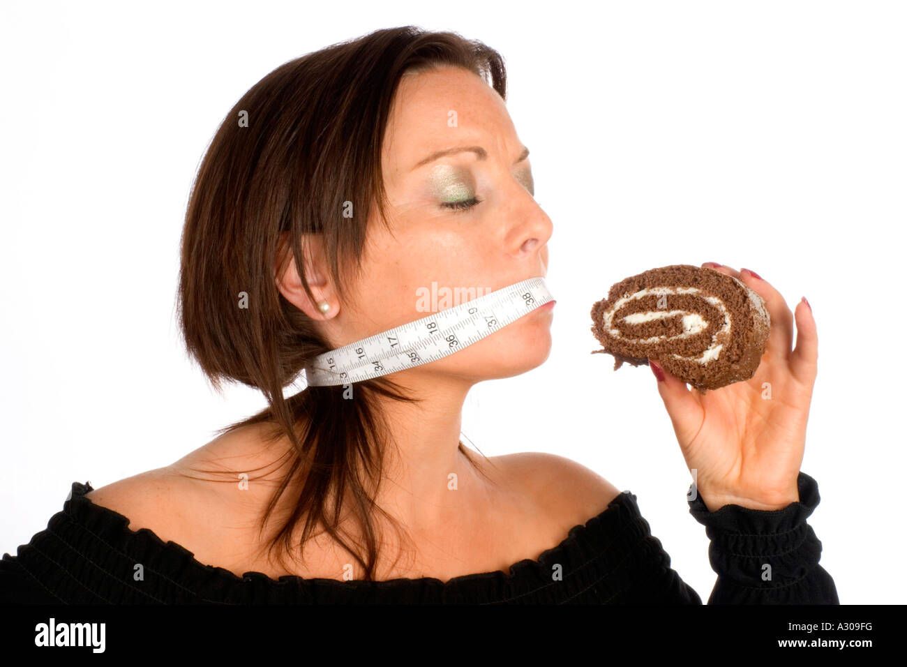 Close up of a young woman holding cake avec du ruban adhésif sur sa bouche Banque D'Images