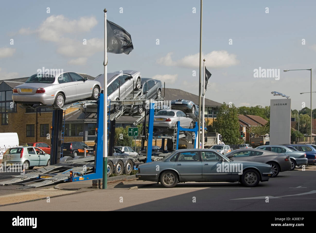 Camion Camion de livraison des voitures à l'entreprise concessionnaire de voiture en route à l'extérieur de la rampe car dealership showroom Jaguar UK Angleterre Essex Banque D'Images