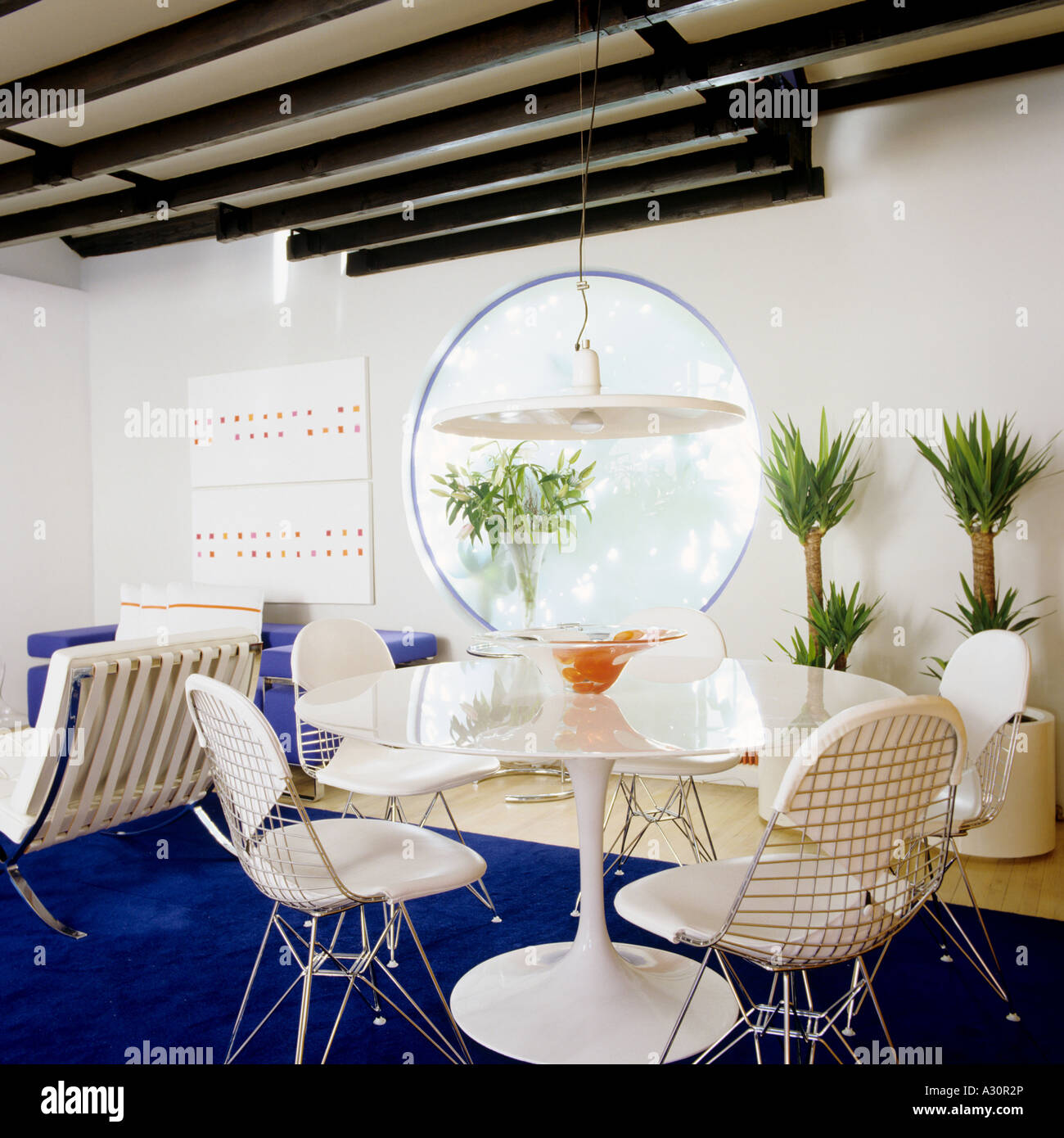 White Tulip table et chaises dans un coin salon avec tapis bleu Banque D'Images