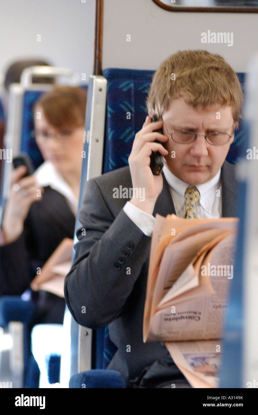 Image libre de photographie de l'homme d'affaires britannique avec FT et le téléphone mobile du trajet quotidien en train London UK Banque D'Images