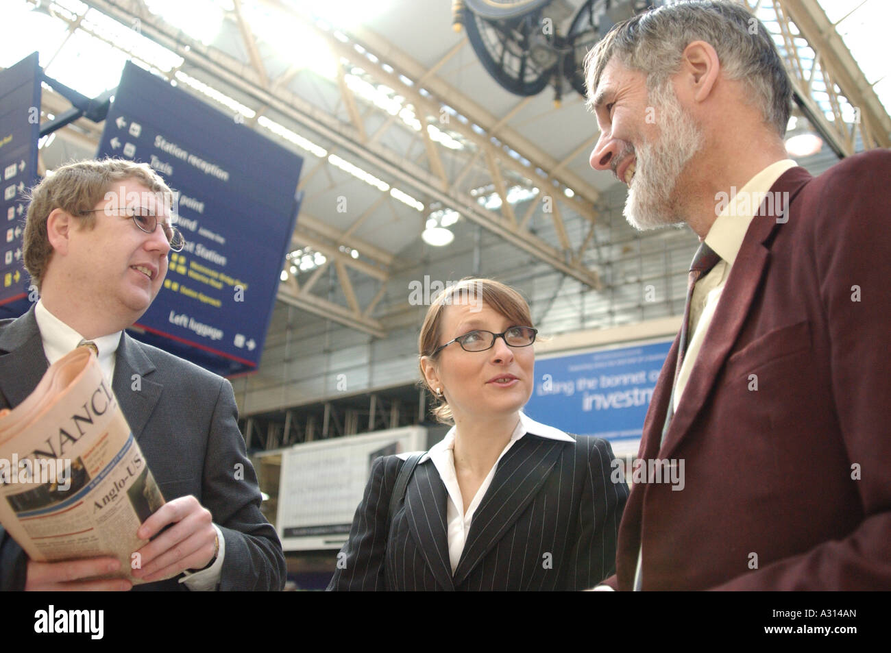 Photographie de trois business people talking avant de prendre le train pour voir les clients en Europe à la gare London UK Banque D'Images