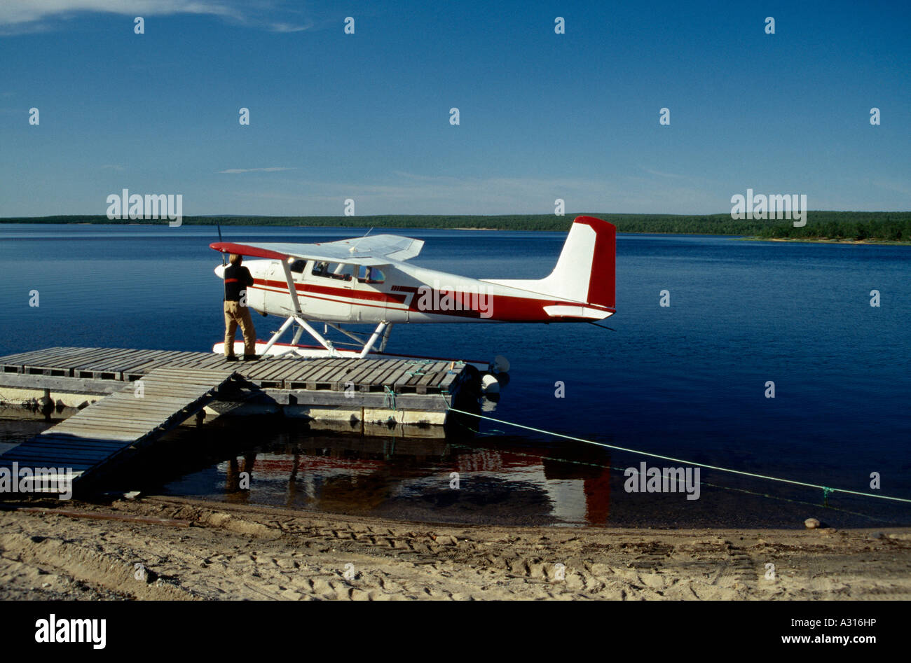 Man Standing on jetty à côté de seaplane Banque D'Images